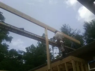 Carpenter setting a ridge beam over a new addition frame — Ice Dam Removal by Roofing Brothers in Saddle Brook