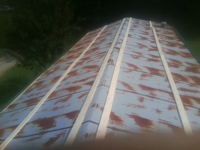Rusted metal roof panels with new wood purlins before replacement — Storm Damage Roof Repair in Saddle Brook by Roofing Brothers