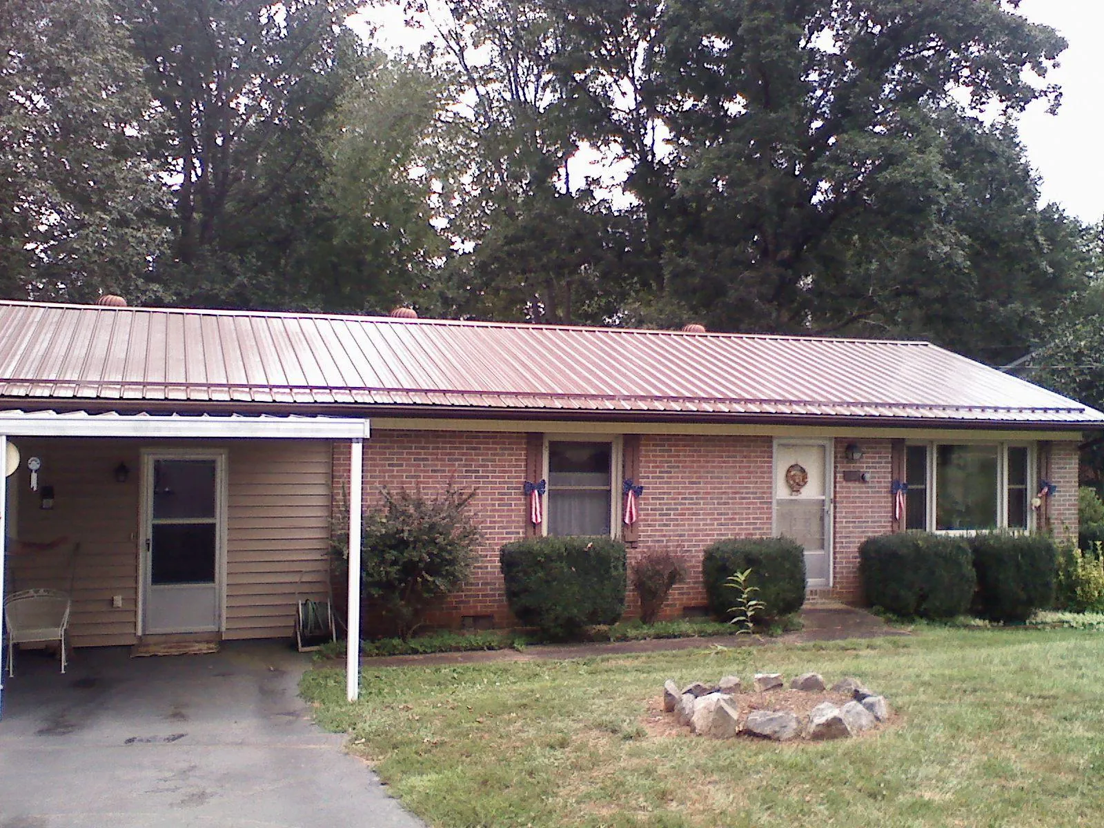 Bronze metal roof and carport on a brick ranch home — Roof Repair work by our crew in Saddle Brook
